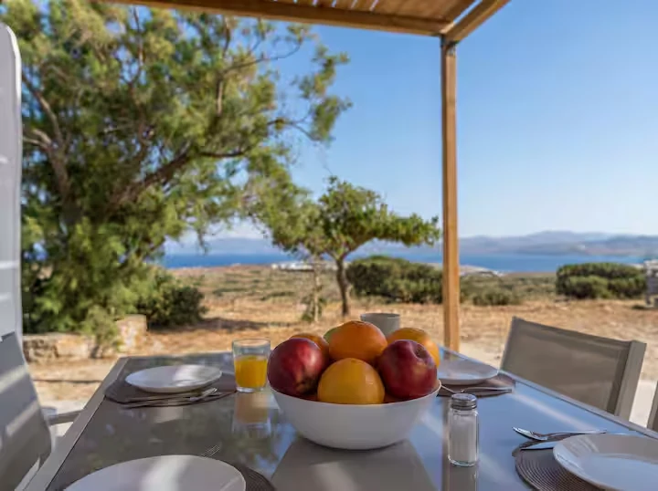 Breakfast table beneath the pergola overlooking the Aegean Sea at Perliti