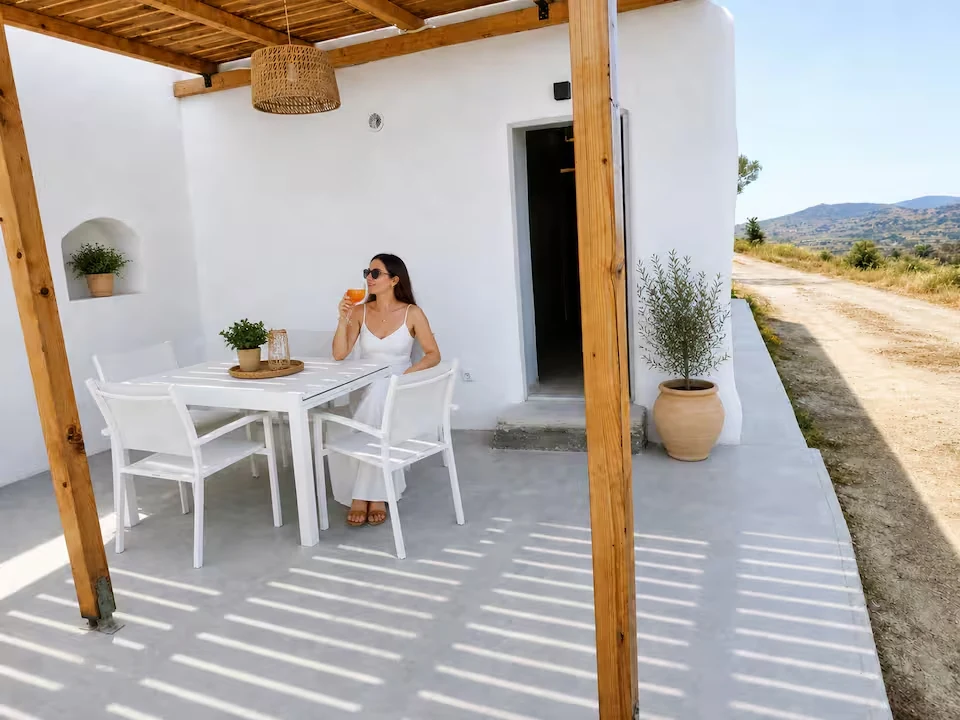 White Cycladic terrace and shaded outdoor dining area at Perliti